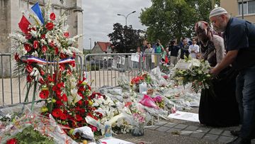 People gather during a minute of silence attended by Muslim worshippers of the Yahya mosque, in front of the Saint Etienne church in Saint-Etienne-du-Rouvray, near Rouen, France,