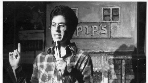 Jerry Seinfeld performing standup at a comedy club