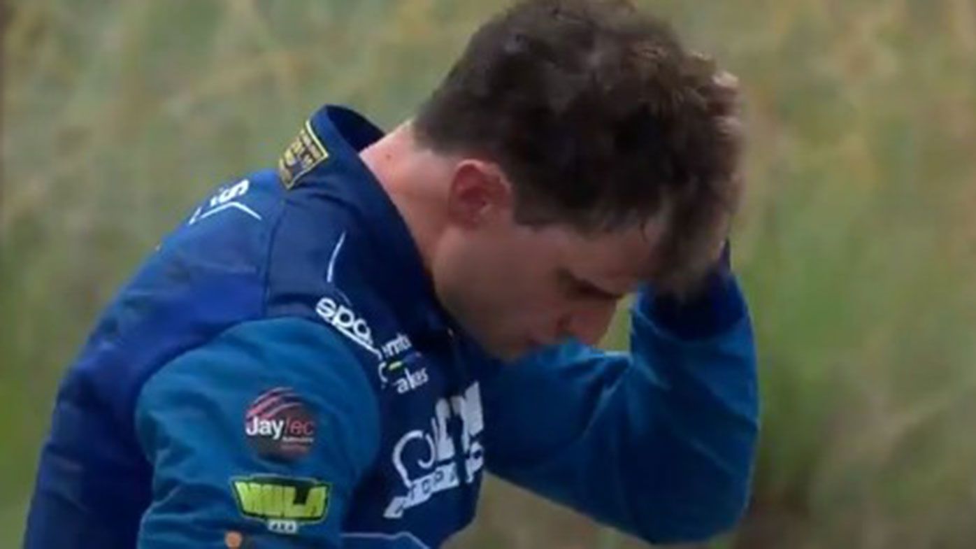 Tim Slade reacts after his huge crash during the opening race of the Supercars championship.