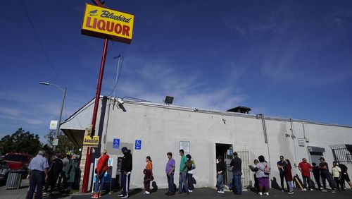 Le persone si mettono in fila per acquistare i biglietti della lotteria per la lotteria Powerball sabato in un negozio di liquori Bluebird a Hawthorne, in California.