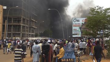 Smoke rises from a government building during a coup in Niger on July 23, 2023.