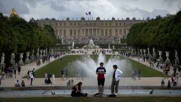 Visitors enjoy the Chateau de Versailles gardens, outside Paris, France, on July 15, 2023.  