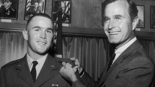 George H.W. Bush, right, is about to pin a lieutenant bar on his son, George W. Bush, after the younger Bush was made an officer in the Texas Air National Guard in Ellington Field, Texas in 1968.