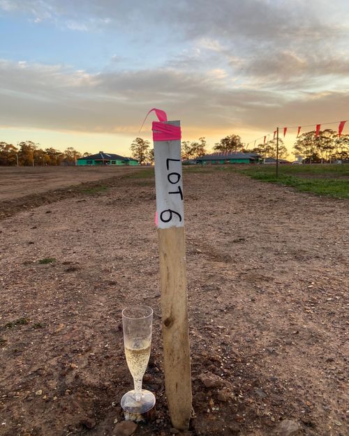 A glass of bubbly sits next to a marker showing Jillian Edelsten's lot number.