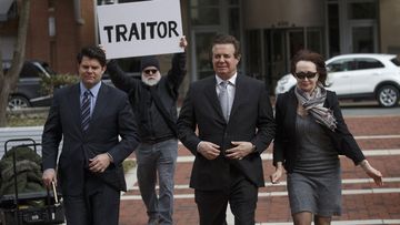 Paul Manafort (centre) is heckled as he walks into court.