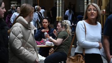 People eat takeaway food in Pitt Street Mall in the CBD of Sydney