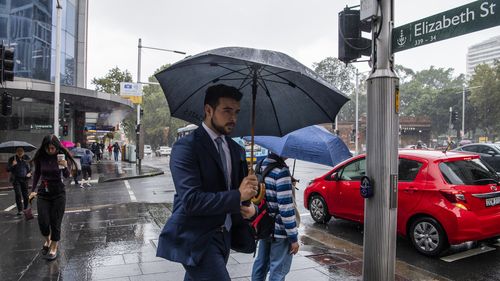 Workers tackle heavy rain in Sydney CBD, with more on the way.