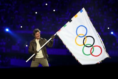 Tom Cruise holds the Olympic flag during the Closing Ceremony of the Olympic Games Paris 2024 at Stade de France on August 11