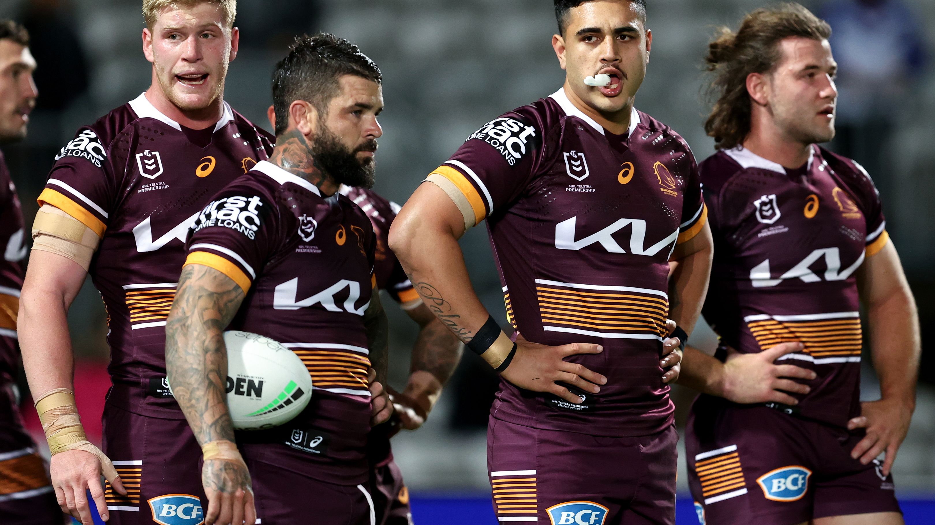 Broncos players react to a loss against the Dragons.