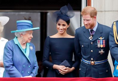 LONDON, UNITED KINGDOM - JULY 10: (EMBARGOED FOR PUBLICATION IN UK NEWSPAPERS UNTIL 24 HOURS AFTER CREATE DATE AND TIME) Queen Elizabeth II, Meghan, Duchess of Sussex and Prince Harry, Duke of Sussex watch a flypast to mark the centenary of the Royal Air Force from the balcony of Buckingham Palace on July 10, 2018 in London, England.