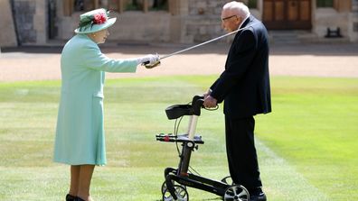 Queen Elizabeth II awards Captain Sir Thomas Moore with the insignia of Knight Bachelor at Windsor Castle on July 17, 2020 in Windsor, England.