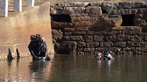 Divers search for the car and the body of the passenger trapped inside.