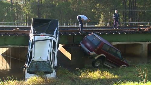 Four people died after these two cars were washed from the road in Caboolture yesterday. (9NEWS)