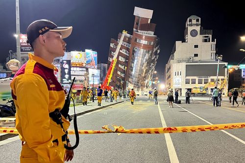 A rescue worker stands near the cordoned off site of a leaning building in the aftermath of an earthquake in Hualien, eastern Taiwan on Wednesday, April 3, 2024