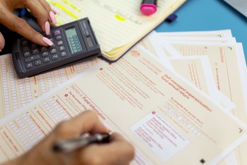 Generic picture of someone filling out a tax return.