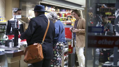 Büyük bir markette alışveriş yapan müşteriler.