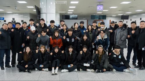 South Korean skiiers make a fist of solidarity before departing for the North for joint ski training with North Korean athletes. (AAP)