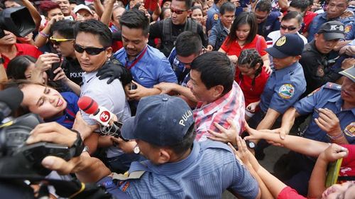 Duterte being mobbed on election day. (AAP)