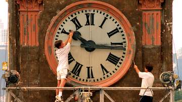 Daylight saving finishes this weekend with the clocks being put back one hour.Pic Shows; Painter, Wayne Fleming of Minchenbury working on the Balmian Post Office Tower clock, playfully trys to stop time while co-worker, David Hamilton works on.