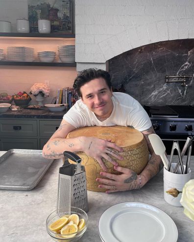 Brooklyn Beckham holding tight to large wheel of cheese