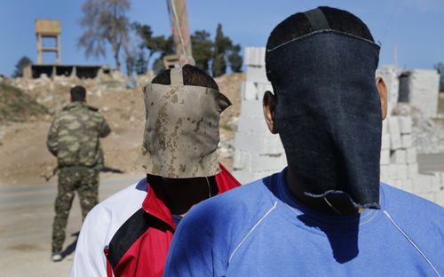 El Shafee Elsheikh, wearing a red, black and white jacket, at a security center in Kobani, Syria. (AAP)