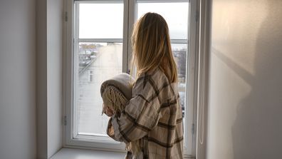 The girl holds a cozy soft blanket in her hands. Warm blanket in the hands of a woman close-up. Winter mood and home textiles