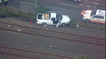 A white ute had been travelling west when it hit a fence and continued onto the tracks.