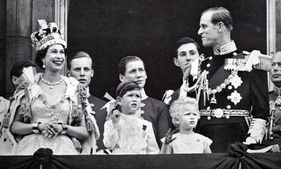 Buckingham Palace balcony, Coronation day 1953. The Queen and the Duke exchange smiles while Prince Charles and Princess Anne are absorbed with the planes roaring overhead. (Photo by: Universal History Archive/Universal Images Group via Getty Images)