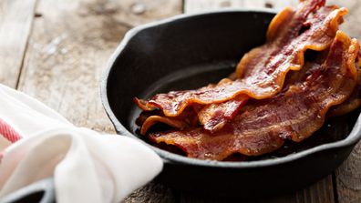 The woman is upset with her mother for frying bacon in her home.