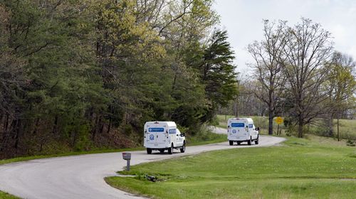 Crime scene investigation vehicles drive up Union Hill Road,  Pike County, Ohio, as they approach the location of a reported multiple shooting. (AAP)
