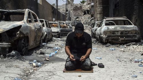 An Iraqi Counter-Terrorism Services member prays in the Old City of Mosul. (AFP)
