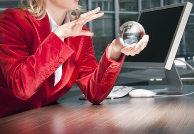 Woman looking into crystal ball in office