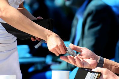 man receiving change after paying the bill for a drink