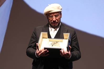 John Travolta accepts the Honorary Palme Award onstage during the 79th annual Cannes Film Festival at Plage Macé on May 15, 2026 in Cannes, France. 