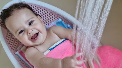 Baby Eliana wearing her waterproof hip spica cast during bath time.