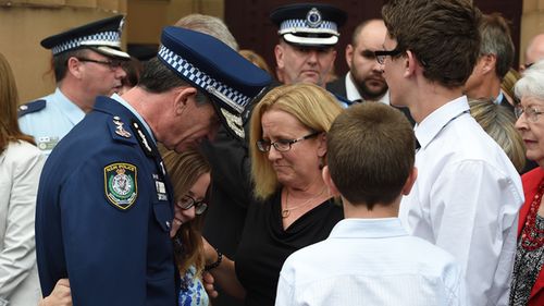 NSW Police Commissioner Andrew Scipione comforts the wife of slain police officer Bryson Anderson, Donna, along with her children, Olivia, Cain and Darcy, as they leave the Supreme Court, in Sydney