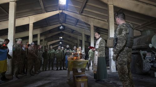 Un sacerdote militare ortodosso guida una messa durante la celebrazione di Pasqua nella posizione in prima linea di 128 brigate dell'esercito ucraino vicino a Zaporizhzhya, Ucraina