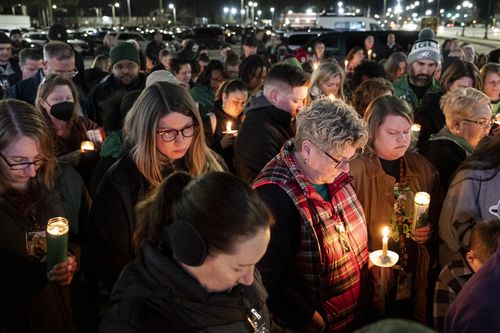 Attendees hold their heads down for a prayer during a vigil for Abby Zwerner, the teacher shot by a 6-year-old student at Richneck Elementary, in front of the Newport News Public Schools Administration Building on Monday, Jan. 9, 2023, in Newport News, Va. 