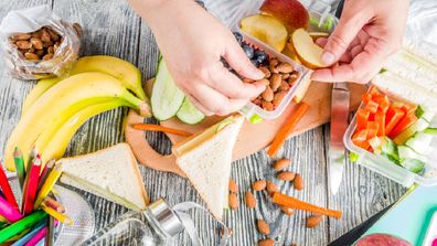 Mother packing multiple school lunch boxes