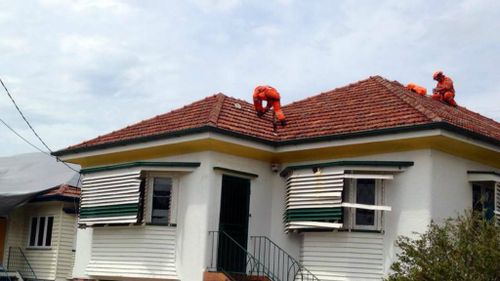 SES workers finish roof repairs on a house in Brisbane. (9NEWS)