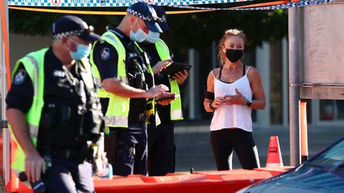 Queensland Police stop a pedestrian in Griffith street Coolangatta at the Queensland border. The Queensland government has tightened border restrictions for people travelling into the state from NSW, with essential workers only permitted to enter with proof of at least one dose of the COVID-19 vaccine. 