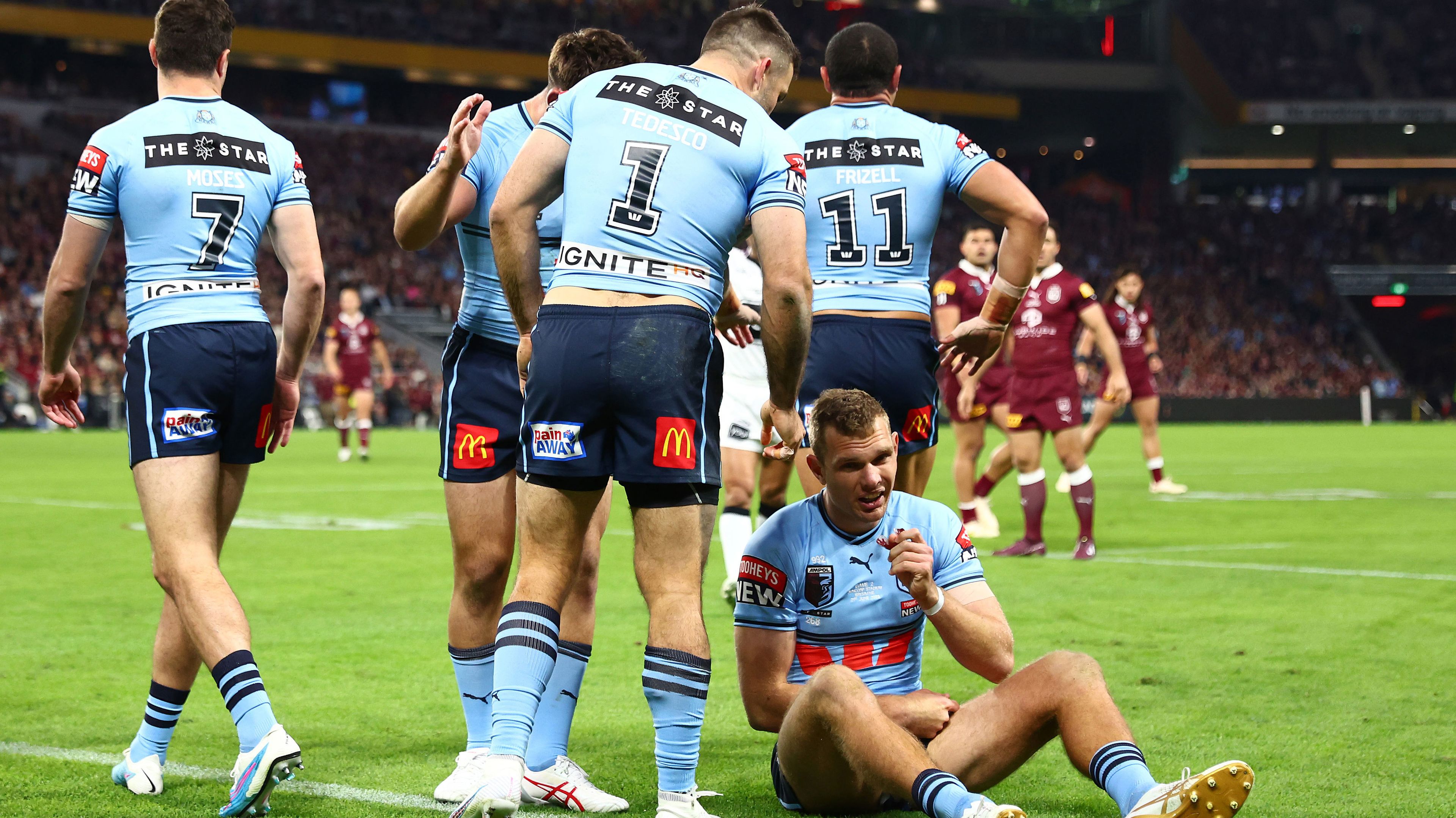 James Tedesco checks on the injured Tom Trbojevic early in NSW&#x27;s loss to Queensland in State of Origin II, 2023.