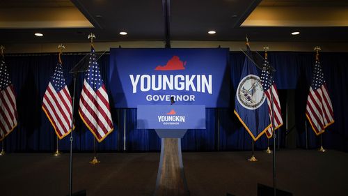 Campaign signs next to a podium during an election night event for Glenn Youngkin. 