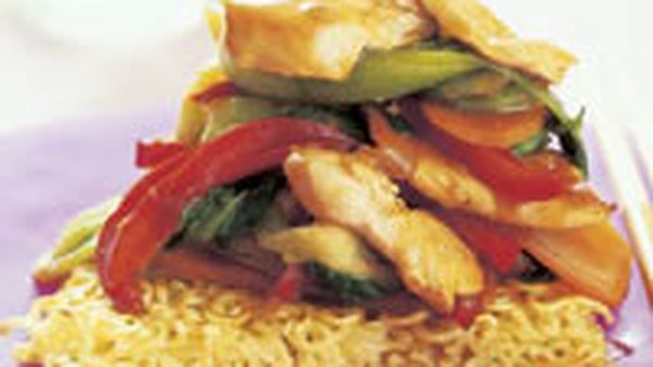 Chicken stir-fry on noodle cakes