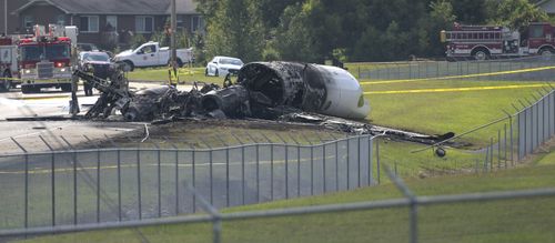 The burned remains of a plane that was carrying NASCAR television analyst and former driver Dale Earnhardt Jr. lie near a runway in Elizabethton, Tennessee.