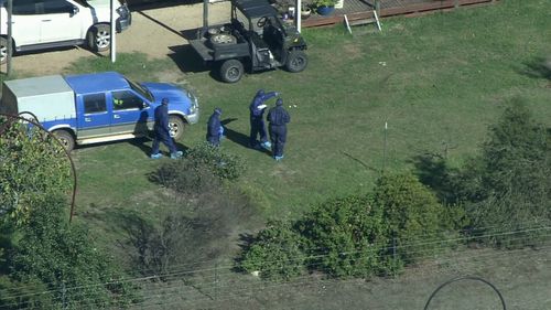 Forensic crews found two firearms at the scene. (9NEWS)