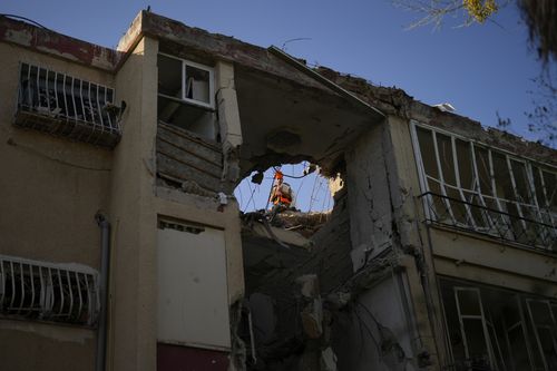 A Israeli soldier inspects a damaged residential building, a day after it was hit by a rocket fired from the Gaza Strip, in Rishon Lezion, Israel, Thursday, Oct. 26, 2023. 