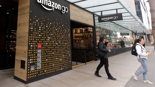 People walk out of an Amazon Go store, Wednesday, March 4, 2020, in Seattle. (AP Photo/Ted S. Warren)