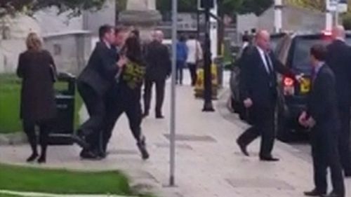 Mr Cameron's security team grab the man as he runs towards the PM. (BBC)