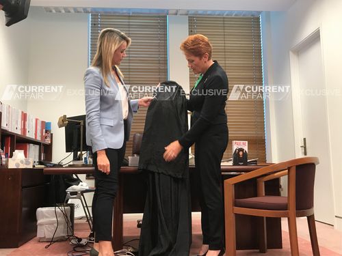 Hanson shows Leila McKinnon her burqa. (A Current Affair)